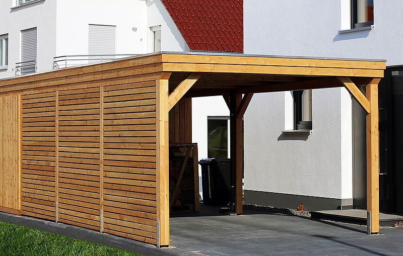 Carport aus Holz an einem modernen, weißen Haus