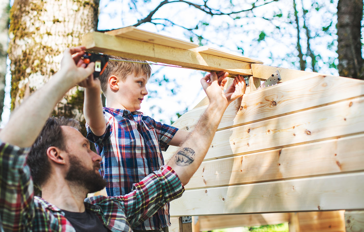 Konstruktionsholz - Vater und Sohn bauen zusammen im Garten